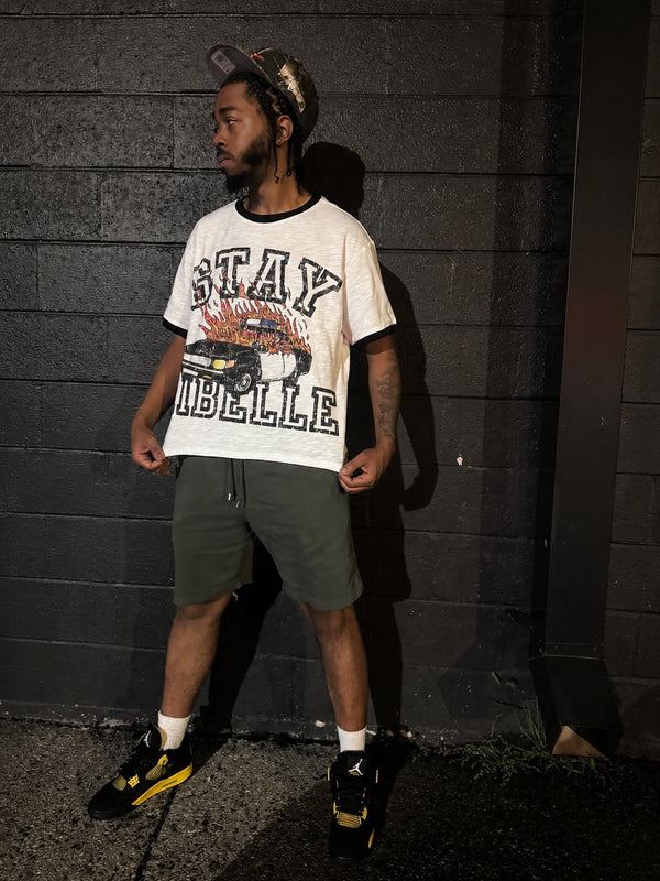 Customer in a cream Stay Ribelle graphic tee and olive shorts