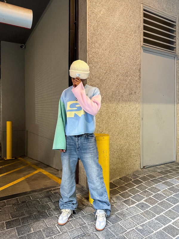 Customer in a pastel colour-block Stay Ribelle sweater and jeans