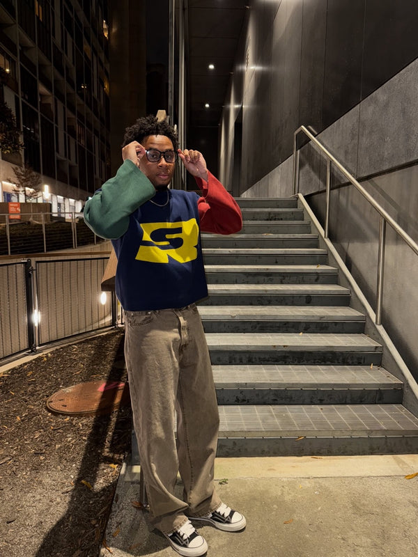 Customer in a navy and green Stay Ribelle logo sweater on a stairwell