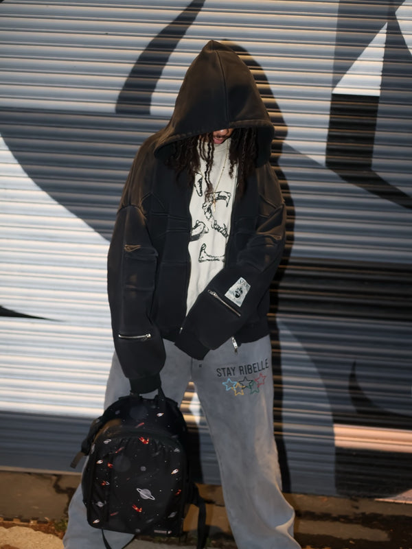 Customer in a black hooded jacket and grey Stay Ribelle sweatpants